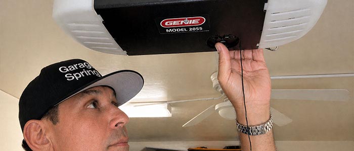 Garage door repair technician replacing a broken grage door opener in San Diego CA.