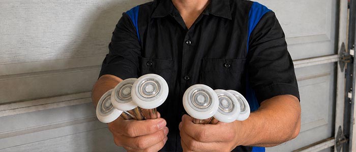 Garage door repair technician displaying a set of upgraded garage door sealed bearing rollers in San Diego CA