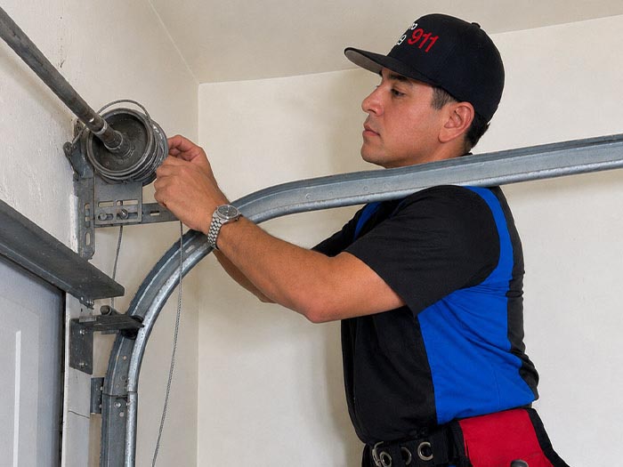 Garage door repair technician replacing a broken cable in San Diego CA.