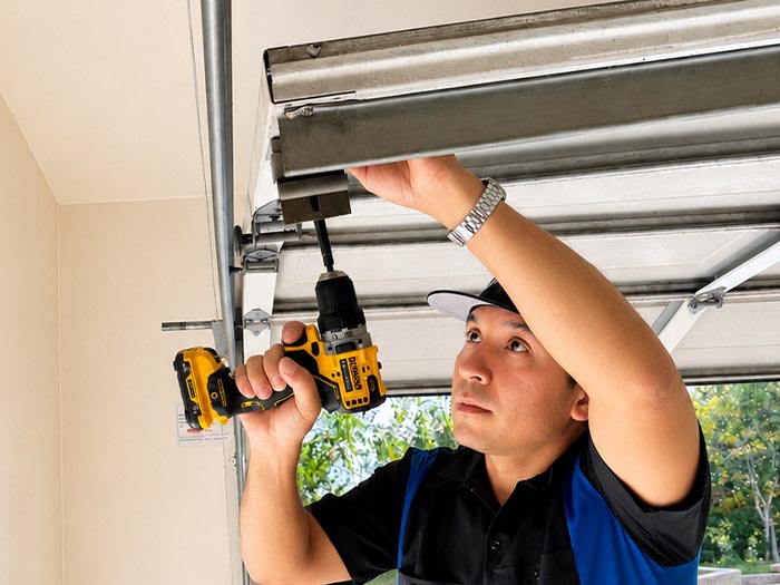 Garage door repair technician fixing a garage door that fell out of its track in San Diego CA.