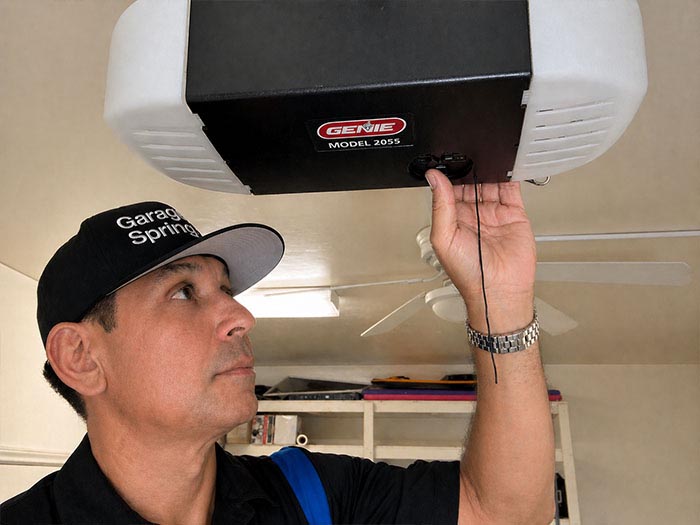 Garage door repair technician replacing a broken grage door opener in San Diego CA.