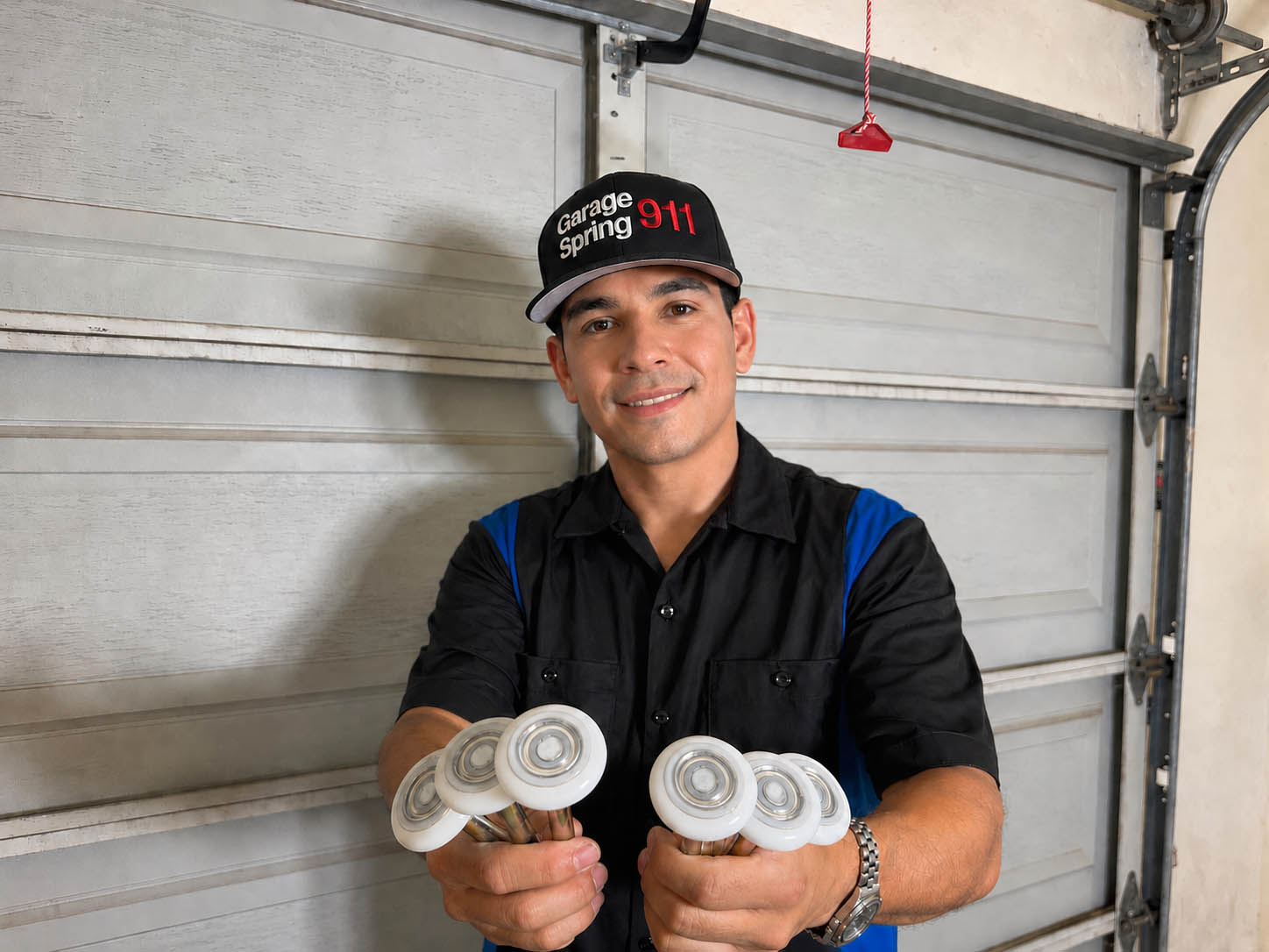 Garage door repair technician displaying a set of upgraded garage door sealed bearing rollers in San Diego CA