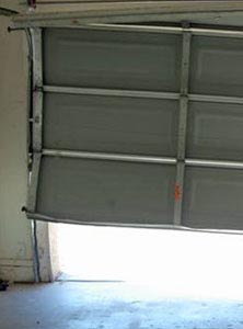 San Diego CA Garage Door Repair, image of a garage door that fell off the tracks.